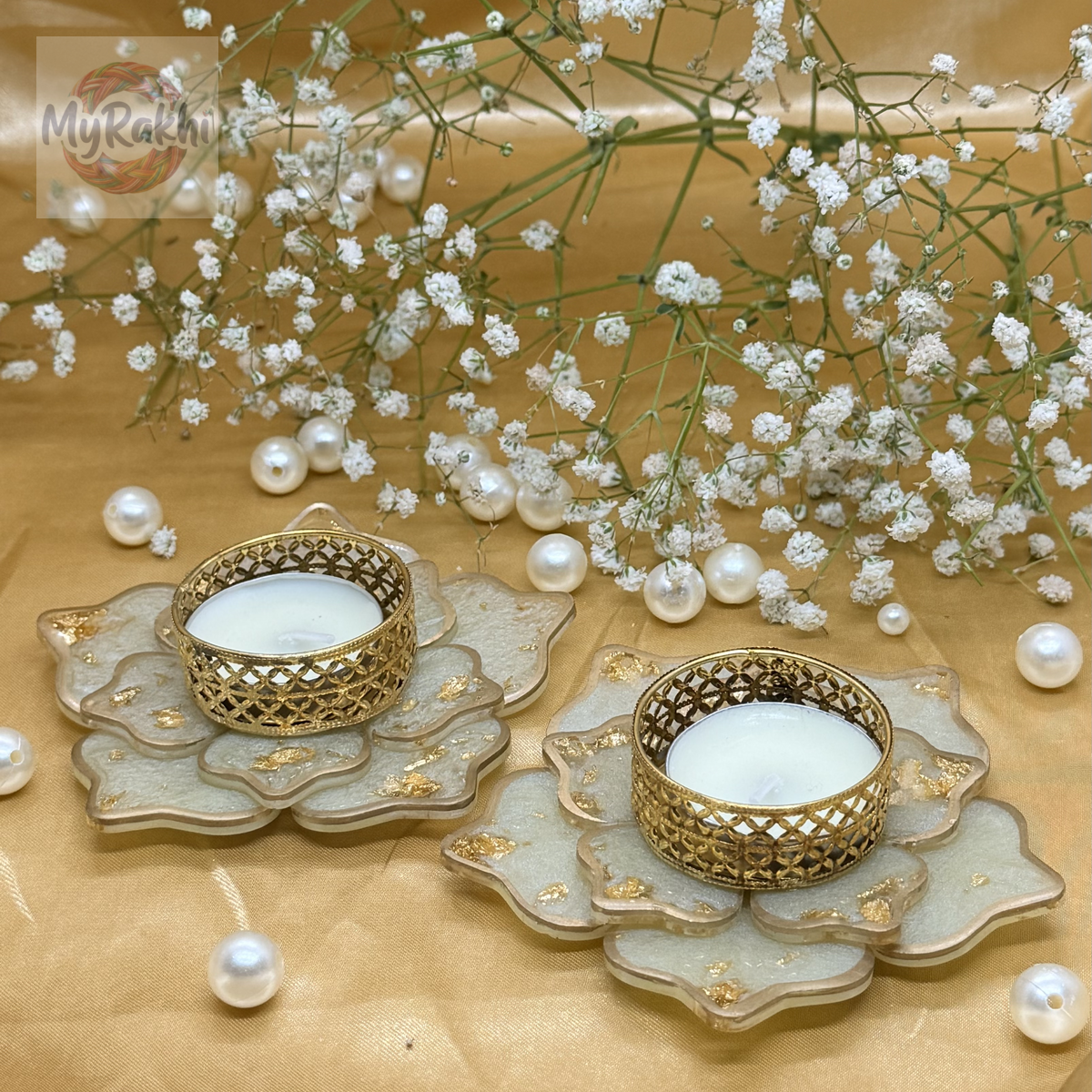 Elegant white resin flower-shaped tealight holders accented with gold leaf and a vintage-style metallic candle cup.