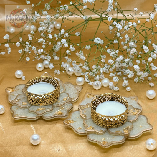 Elegant white resin flower-shaped tealight holders accented with gold leaf and a vintage-style metallic candle cup.